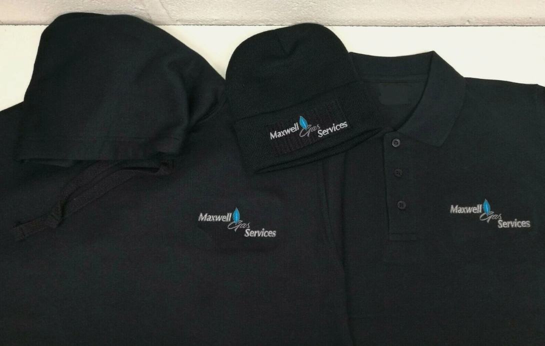 Two black polo shirts with Maxwell Services logo on a white background