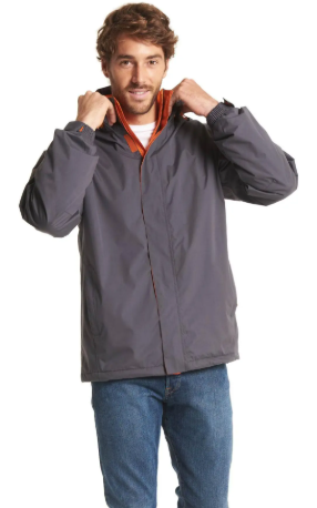 A man wearing a dark gray hooded jacket with an orange inner collar, paired with blue jeans, posing against a white background.