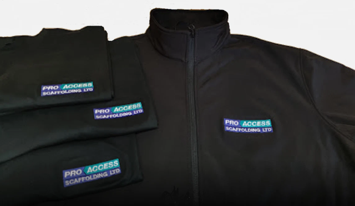 Black jacket with multiple 'Pro Access Scaffolding Ltd' patches on a white background